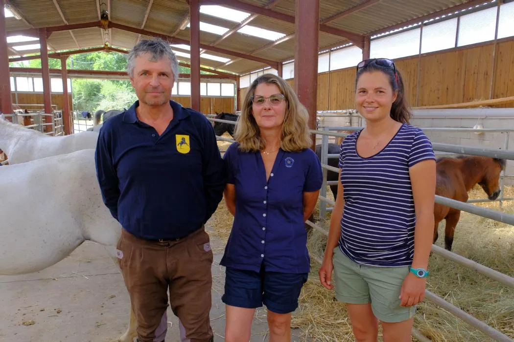 L'équipe du Poney Club de la Forge auprès des chevaux, dans les box du centre